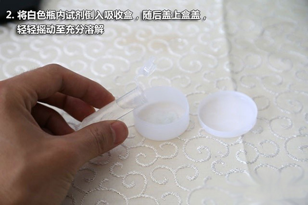 2、將白色瓶內試劑導入吸收盒，隨后蓋上盒蓋，輕輕搖動至充分溶解
